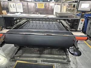 Industrial conveyor belt cutting machine at Premier Belting Services facility.