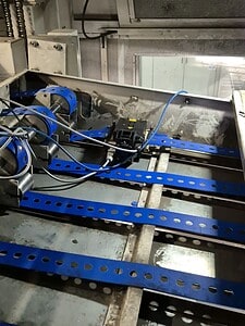 Conveyor belt system with blue belts and sensors for efficient material handling.