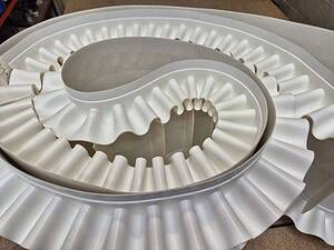 Conveyor belt with white rubber rollers for industrial use.